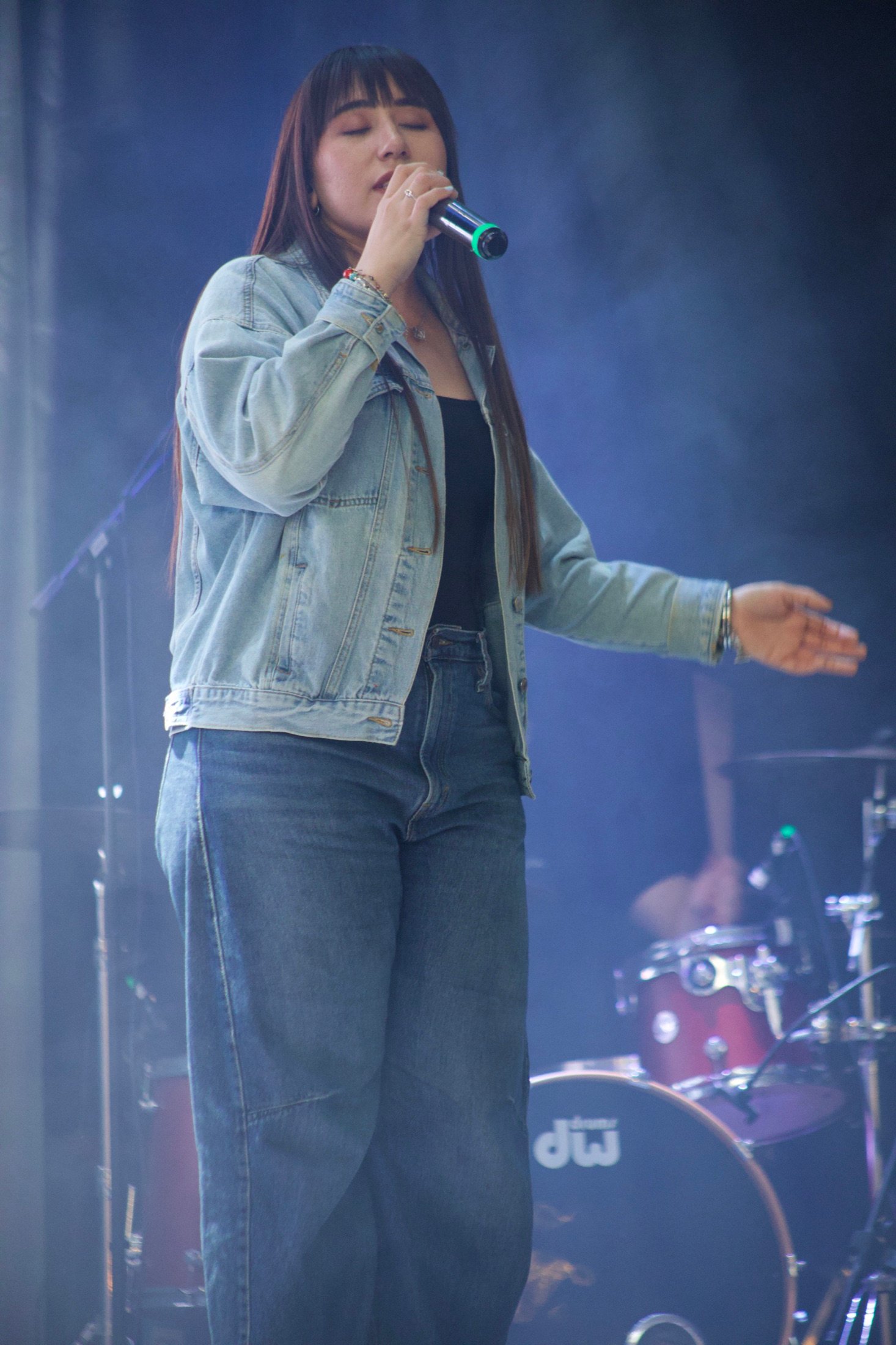 Artista cantando en un escenario con iluminación azul